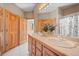 Bathroom with double sinks, wood cabinets, and tiled floor, plus a shower/tub combo at 11421 Belle Meade Dr, Conifer, CO 80433