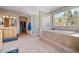 Bright bathroom features a large tub with tile surround and glass block shower wall, plus a walk-in closet at 11421 Belle Meade Dr, Conifer, CO 80433