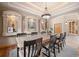 Elegant dining room featuring a spacious table, decorative wall niches, and tray ceiling with accent lighting at 11421 Belle Meade Dr, Conifer, CO 80433
