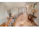 Hallway overlooking stone fireplace and featuring tile floors and wooden banister at 11421 Belle Meade Dr, Conifer, CO 80433