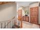 Well-lit hallway with wooden railing and trim, and a view of the wooded outdoors at 11421 Belle Meade Dr, Conifer, CO 80433