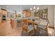 Open kitchen featuring light wood cabinets, hardwood floors and a breakfast table near a large window at 11421 Belle Meade Dr, Conifer, CO 80433