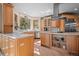 Bright kitchen with custom wood cabinets, quartz countertops, and modern stainless steel appliances and views at 11421 Belle Meade Dr, Conifer, CO 80433