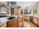 Bright kitchen with hardwood floors, a kitchen island, stainless steel appliances, and views of the surrounding greenery at 11421 Belle Meade Dr, Conifer, CO 80433