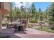 Inviting deck featuring an outdoor kitchen, fireplace, and dining area, ideal for alfresco entertaining amidst nature at 11421 Belle Meade Dr, Conifer, CO 80433
