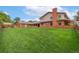 Large backyard with a well maintained lawn, a brick house, and wooden fence at 10101 W 72Nd Ave, Arvada, CO 80005