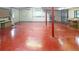 Finished basement space with red flooring and a roll-up garage door at 10101 W 72Nd Ave, Arvada, CO 80005