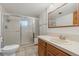 Bathroom featuring tiled shower and single sink vanity with wood cabinets at 10101 W 72Nd Ave, Arvada, CO 80005