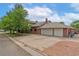 Three car garage with driveway, lawn and mature landscaping at 10101 W 72Nd Ave, Arvada, CO 80005