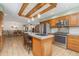 Traditional kitchen with stainless steel appliances, wood cabinets, tile floor, and a beamed ceiling at 10101 W 72Nd Ave, Arvada, CO 80005