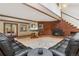 Cozy living room with a brick fireplace, exposed beams, and comfortable leather seating at 10101 W 72Nd Ave, Arvada, CO 80005