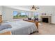 Bright main bedroom featuring a ceiling fan, a brick fireplace, and an expansive window view at 10101 W 72Nd Ave, Arvada, CO 80005