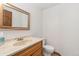 Well lit half-bathroom with oak vanity and stylish fixtures at 10101 W 72Nd Ave, Arvada, CO 80005