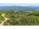 Sweeping aerial shot showcasing the property's serene mountain setting and the lush landscape surrounding it at 11457 Nancys Dr, Conifer, CO 80433