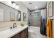Updated bathroom with modern vanity, framed mirror, and tiled shower/tub combo at 11457 Nancys Dr, Conifer, CO 80433