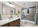 Modern bathroom showcasing a vanity, black framed mirror and a glass-enclosed shower at 11457 Nancys Dr, Conifer, CO 80433