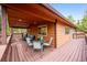 Charming home featuring a spacious covered deck with a dining table and seating, ideal for outdoor entertaining at 11457 Nancys Dr, Conifer, CO 80433
