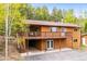 Two-story home features wood siding, a brown roof, and an expansive deck perfect for outdoor living at 11457 Nancys Dr, Conifer, CO 80433