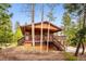 Exterior front view of the home with a large deck and stairs at 11457 Nancys Dr, Conifer, CO 80433