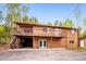 Exterior view of two story home with spacious deck and driveway at 11457 Nancys Dr, Conifer, CO 80433