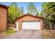 Detached garage with a white door, offering ample parking and storage space at 11457 Nancys Dr, Conifer, CO 80433