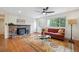 Cozy living room with wood floors, a wood-burning fireplace, and large windows at 11457 Nancys Dr, Conifer, CO 80433