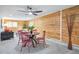 Comfortable living space with wood paneled walls, a round table with red chairs, and a cozy seating area at 11457 Nancys Dr, Conifer, CO 80433