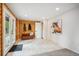 Mud room featuring wooden paneling, tiled flooring, a wooden bench, and an adjacent room with a horse picture at 11457 Nancys Dr, Conifer, CO 80433