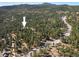 Wide aerial view pointing to a home situated in a lush, tree-filled landscape with mountain views at 31948 Highway 72, Golden, CO 80403