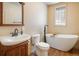 Relaxing bathroom with modern soaking tub, sleek fixtures, and a bright glass block window at 31948 Highway 72, Golden, CO 80403