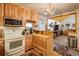A well-lit kitchen featuring light wood cabinetry, stainless steel appliances, and an antler chandelier at 31948 Highway 72, Golden, CO 80403