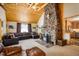 Spacious living room with a stone fireplace, wood ceilings, and comfortable seating area at 31948 Highway 72, Golden, CO 80403