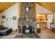 Cozy living room featuring a stone fireplace, wood beam ceilings, and rustic decor at 31948 Highway 72, Golden, CO 80403