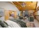 A spacious bedroom featuring a stone fireplace, wood ceilings, and comfortable seating area at 31948 Highway 72, Golden, CO 80403