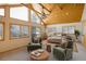 Bright main bedroom features vaulted wood ceilings, sitting area and large windows showcasing serene, snowy views at 31948 Highway 72, Golden, CO 80403