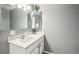 Bathroom featuring a vanity with white countertop and large mirror with decorative lighting at 12097 E Mexico Ave, Aurora, CO 80012