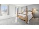 Light filled primary bedroom featuring a four poster bed, light gray walls and carpet at 12097 E Mexico Ave, Aurora, CO 80012