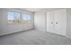 Bright bedroom with gray carpet, neutral walls, two windows, and a closet at 12097 E Mexico Ave, Aurora, CO 80012