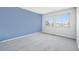 Spacious bedroom features gray carpet, blue accent wall, and two windows allowing plenty of natural light at 12097 E Mexico Ave, Aurora, CO 80012