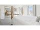 Bright bedroom featuring a four-poster bed, mirrored closet doors and neutral tones at 12097 E Mexico Ave, Aurora, CO 80012