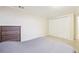 Bedroom with neutral walls and carpet features a closet at 12097 E Mexico Ave, Aurora, CO 80012