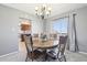 Elegant dining area featuring a round table, chandelier, and natural light from a large window at 12097 E Mexico Ave, Aurora, CO 80012