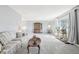 Spacious living room with carpet, large window, and ample natural light for plants and decor at 12097 E Mexico Ave, Aurora, CO 80012