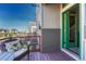 Charming outdoor balcony featuring wicker chair with sunflower pillow and a green door at 5654 N Emporia St, Denver, CO 80238