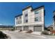 Modern townhome exterior with a three-car garage and contemporary architectural details under a blue sky at 5654 N Emporia St, Denver, CO 80238