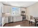 Modern kitchen featuring white cabinets, stainless steel appliances, quartz countertops, and a stylish backsplash under a bright window at 5654 N Emporia St, Denver, CO 80238