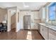 Spacious kitchen with stainless steel appliances, white cabinets, tile backsplash, and hardwood floors at 5654 N Emporia St, Denver, CO 80238