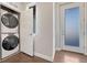 Convenient laundry area with stacked washer and dryer units, a bright window, and easy access to the main living space at 5654 N Emporia St, Denver, CO 80238