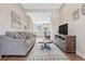 Comfortable living room with a view into the kitchen, featuring hardwood floors, a sofa, and a sleek entertainment center at 5654 N Emporia St, Denver, CO 80238