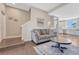 Open-concept living room flowing into the kitchen, featuring hardwood floors, a cozy sofa, and stairs to the upper level at 5654 N Emporia St, Denver, CO 80238